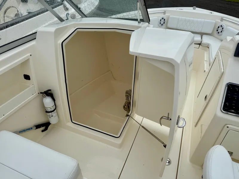 Slide: The Image of 2021 Cobia 220 Dual Console boat interior with open storage compartment. - 14