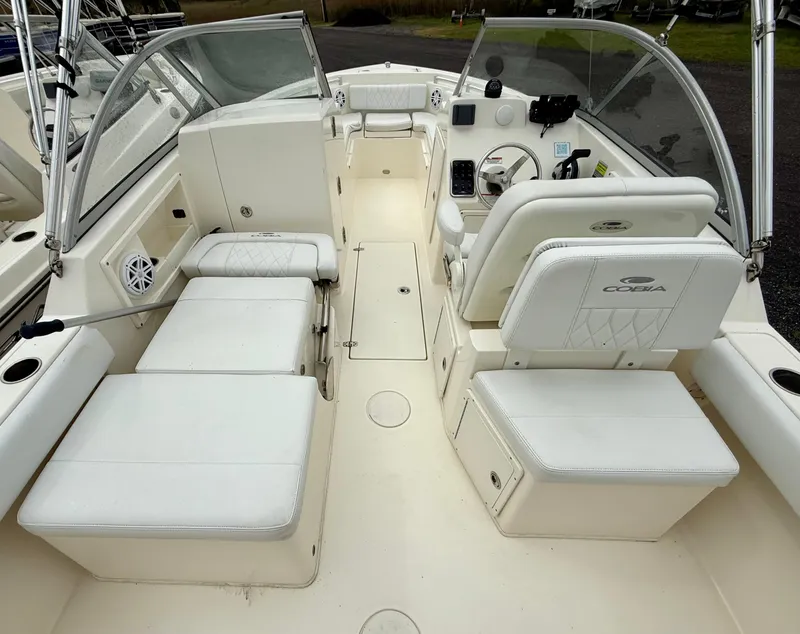 Slide: The Image of 2021 Cobia 220 Dual Console boat interior with white seating and steering console. - 4