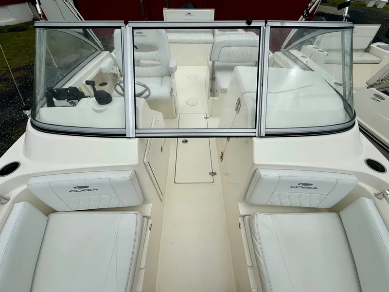 Slide: The Image of 2021 Cobia 220 Dual Console boat interior with white seating and windshield. - 5