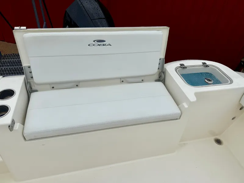 Slide: The Image of 2021 Cobia 220 Dual Console boat seat and livewell, featuring white upholstery. - 7