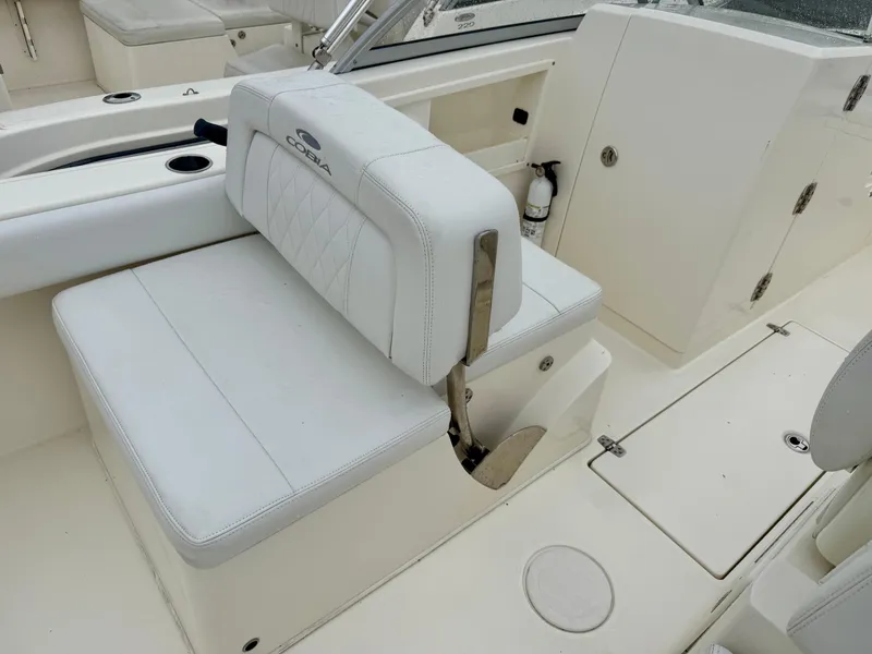 Slide: The Image of 2021 Cobia 220 Dual Console boat interior with white seating and storage compartments. - 9