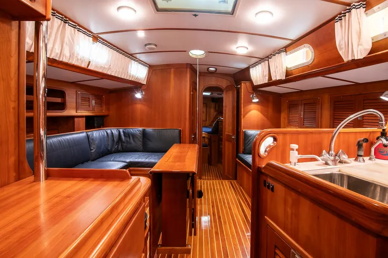 Slide: The Image of Luxurious interior of 1993 Hinckley Sou'wester 51 yacht with wood finish and blue seating. - 25