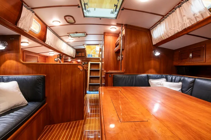 Slide: The Image of 1993 Hinckley Sou'wester 51 yacht interior with wooden furnishings and cozy seating. - 33