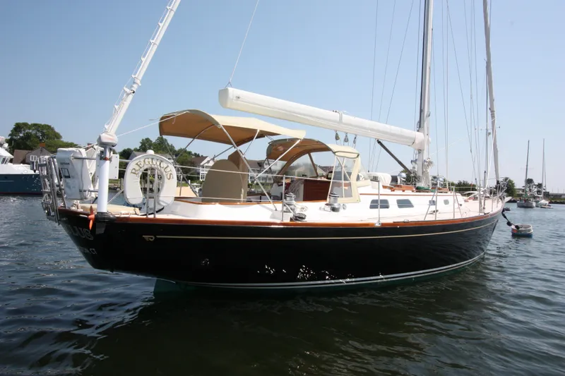 Slide: The Image of Hinckley Sou'wester 51 sailboat, 1993 model, docked on calm water under clear sky. - 4