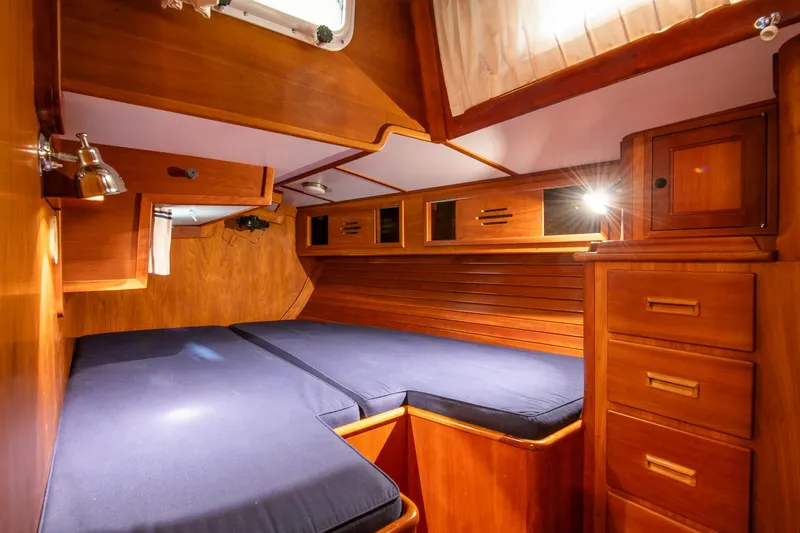 Slide: The Image of Cabin interior of 1993 Hinckley Sou'wester 51 sailboat with wooden finish and blue bedding. - 40