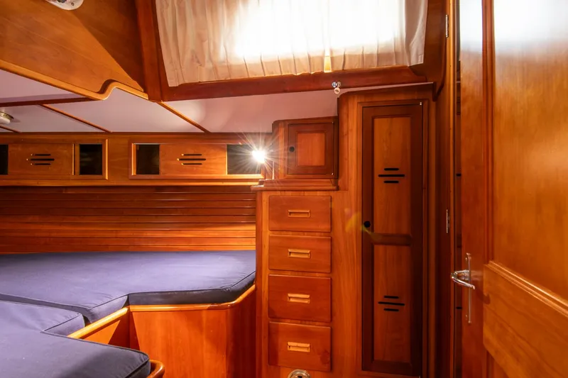Slide: The Image of Hinckley Sou'wester 51 (1993) cabin interior with wooden cabinetry and blue cushions. - 41