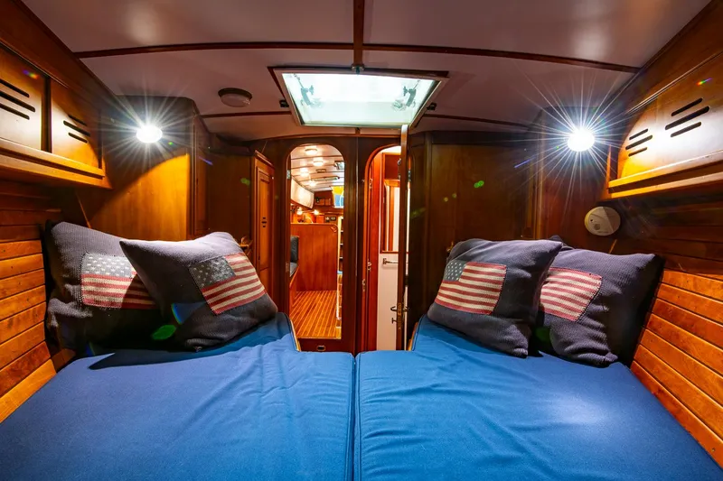 Slide: The Image of Cozy cabin interior of 1993 Hinckley Sou'wester 51 sailboat with blue bedding and American flag pillows. - 42
