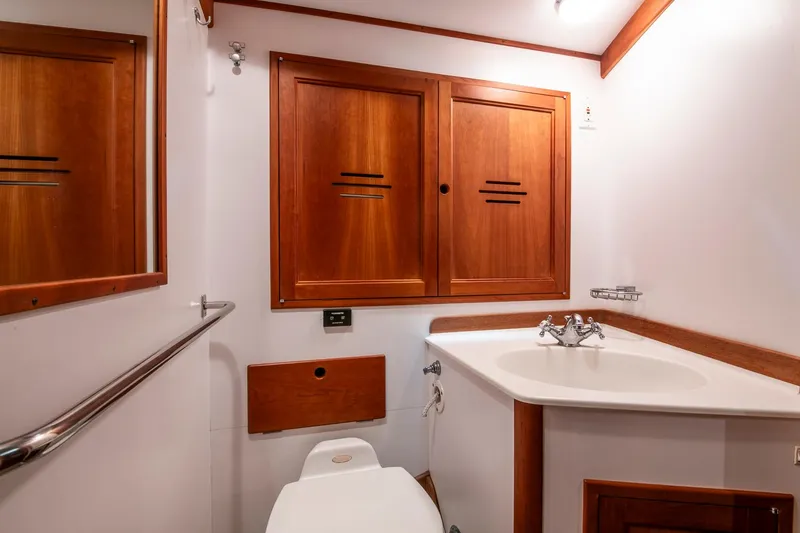 Slide: The Image of Hinckley Sou'wester 51 yacht bathroom, 1993 model, featuring wooden cabinetry and modern fixtures. - 46