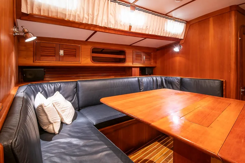 Slide: The Image of Interior of 1993 Hinckley Sou'wester 51 yacht with wooden table and blue seating. - 29