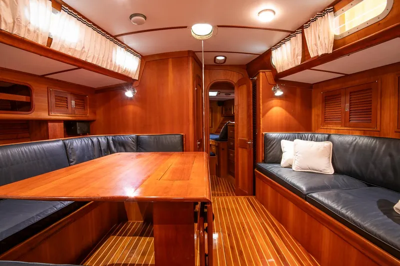 Slide: The Image of Luxurious interior of 1993 Hinckley Sou'wester 51 yacht with wooden finishes and blue seating. - 32