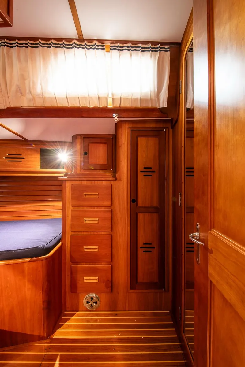 Slide: The Image of Interior of 1993 Hinckley Sou'wester 51 yacht with wooden cabinetry and cozy sleeping area. - 43