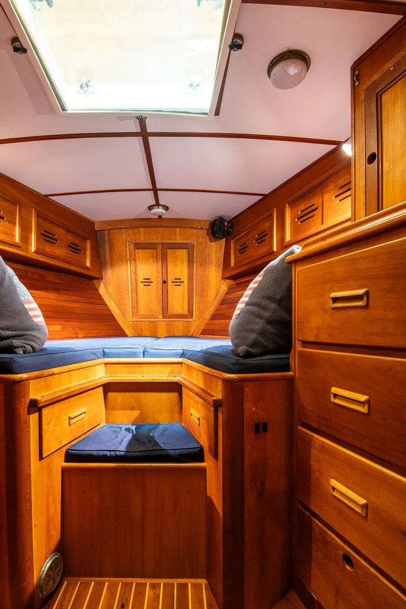 Slide: The Image of Hinckley Sou'wester 51 cabin interior, 1993 model, featuring wooden cabinetry and cozy bedding. - 44