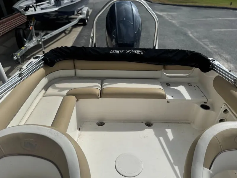 Slide: The Image of 2016 Key West 203 DFS boat interior with beige seating and black motor cover. - 5