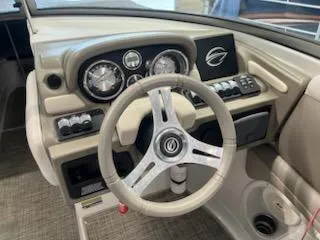 Slide: The Image of Steering wheel and dashboard of 2016 Crownline E4 boat, featuring gauges and controls. - 19