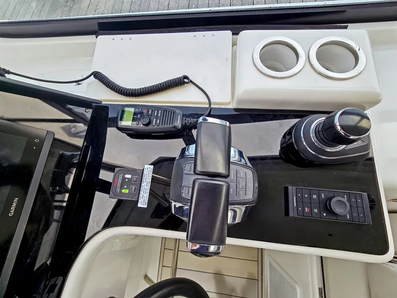 Slide: The Image of Control panel of 2020 Aquila 36 Sport boat with throttle, radio, and cup holders. - 12