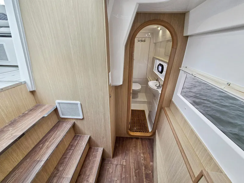 Slide: The Image of Interior of 2020 Aquila 36 Sport yacht, featuring wooden stairs and a compact bathroom. - 18