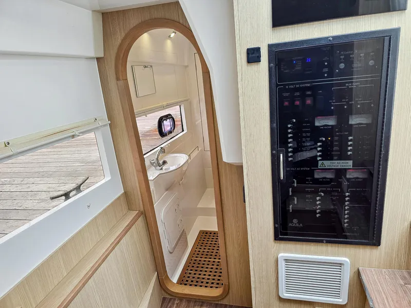 Slide: The Image of Interior of 2020 Aquila 36 Sport yacht, featuring a compact bathroom and control panel. - 24