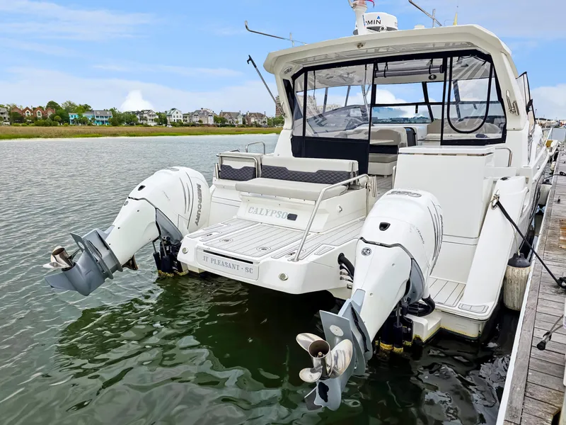 Slide: The Image of Aquila 36 Sport 2020 boat docked, featuring dual outboard motors and spacious seating. - 3