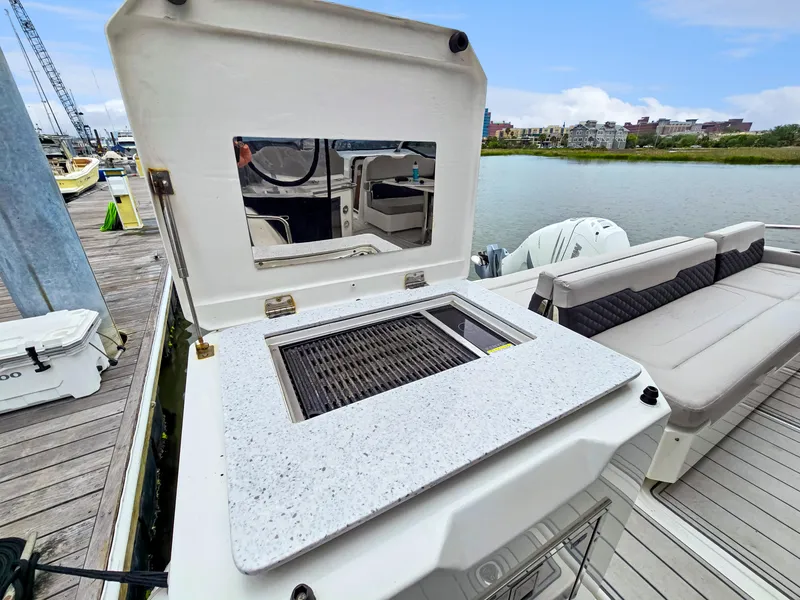 Slide: The Image of Aquila 36 Sport 2020 boat with outdoor grill and seating area on a dock. - 31