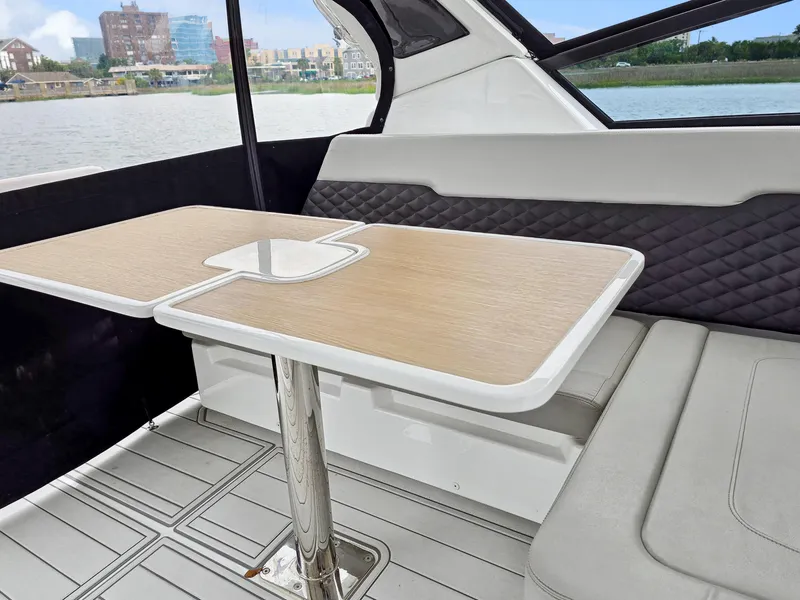 Slide: The Image of Interior of 2020 Aquila 36 Sport boat with seating and wooden table by the water. - 42