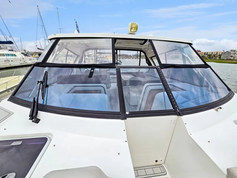 Slide: The Image of 2020 Aquila 36 Sport boat with sleek windshield design in marina setting. - 46
