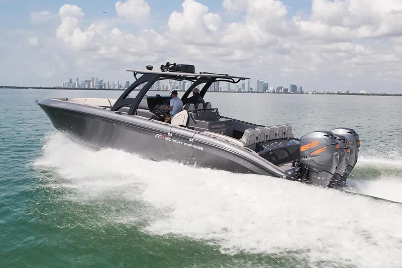 Slide: The Image of 2023 Midnight Express 37' Open boat cruising on water with city skyline in background. - 4