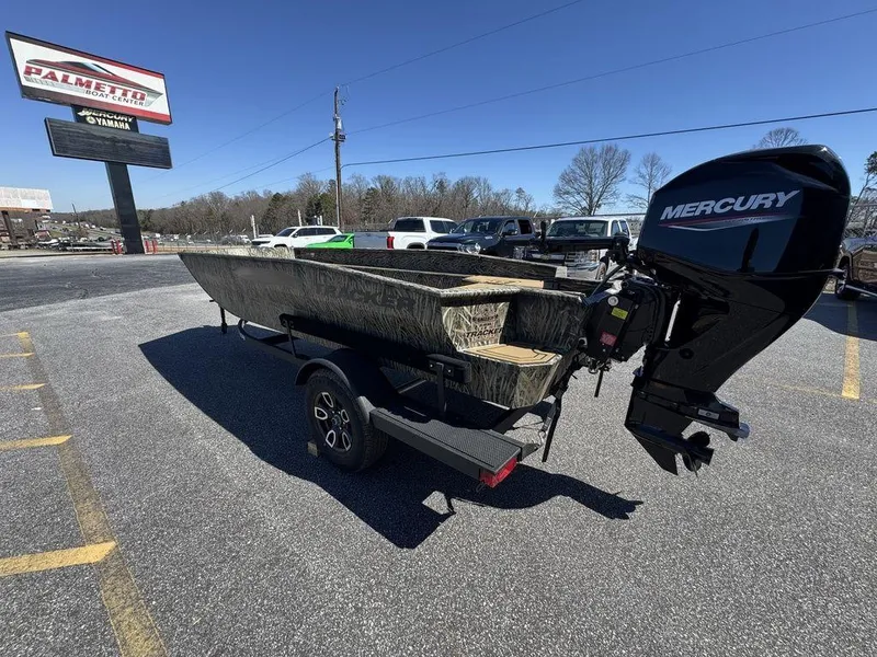 Slide: The Image of 2025 Tracker Grizzly 1650 T Prairie Wings Edition boat with Mercury engine in parking lot. - 11