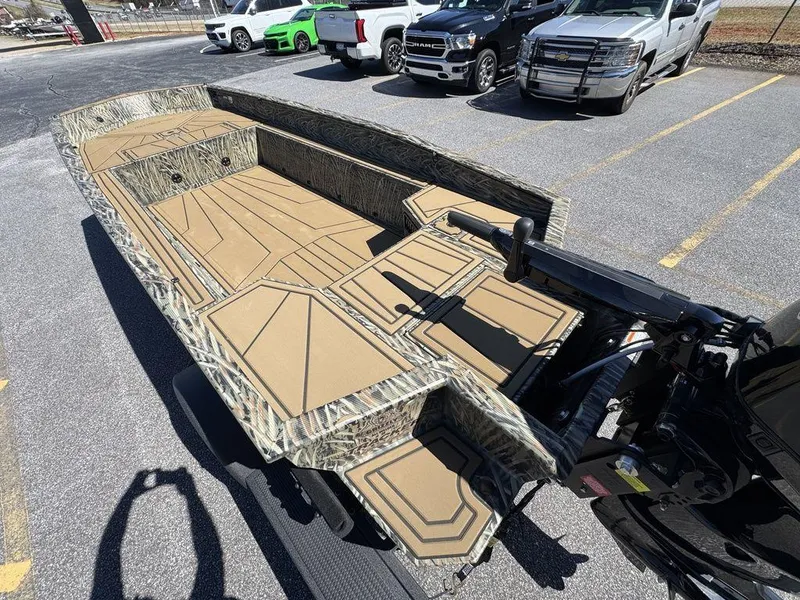 Slide: The Image of 2025 Tracker Grizzly 1650 T Prairie Wings Edition boat in parking lot, camo design. - 12