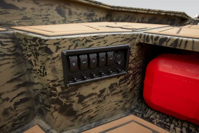 Slide: The Image of 2025 Tracker Grizzly 1650 T Prairie Wings Edition boat interior with control panel and camouflage design. - 38