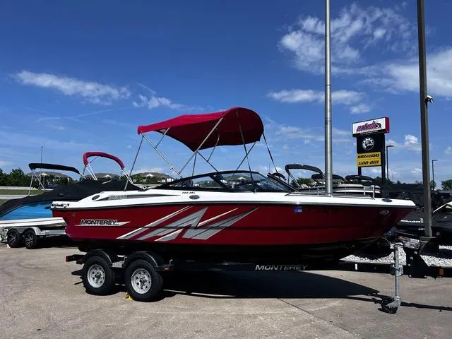 Slide: The Image of 2016 Monterey 196MS boat with red canopy on trailer, parked outdoors under blue sky. - 1