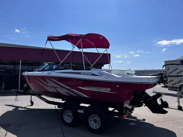 Slide: The Image of Red 2016 Monterey 196MS boat with canopy on trailer, parked outdoors under clear sky. - 7