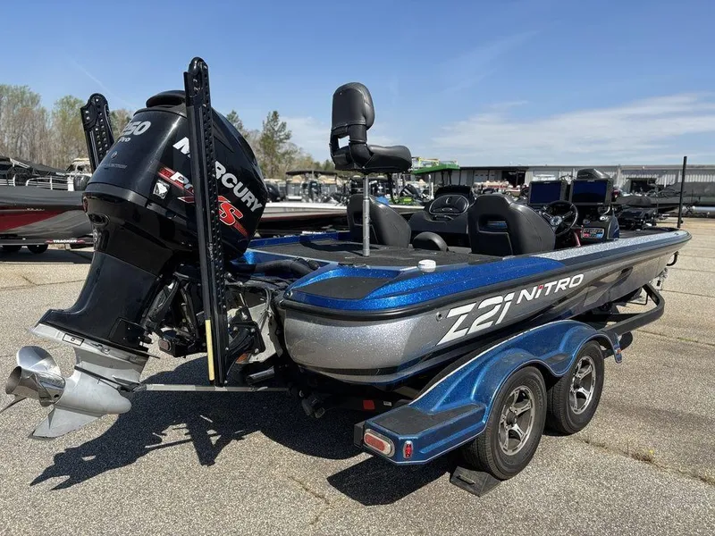 Slide: The Image of 2018 Nitro Z21 boat with Mercury engine on trailer, parked outdoors. - 2