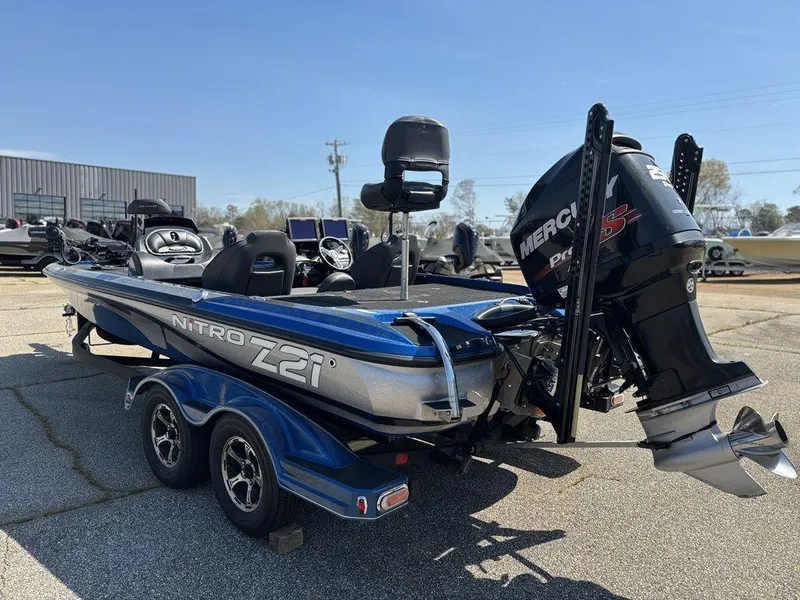 Slide: The Image of 2018 Nitro Z21 boat with Mercury engine, parked on a trailer in a sunny outdoor setting. - 6