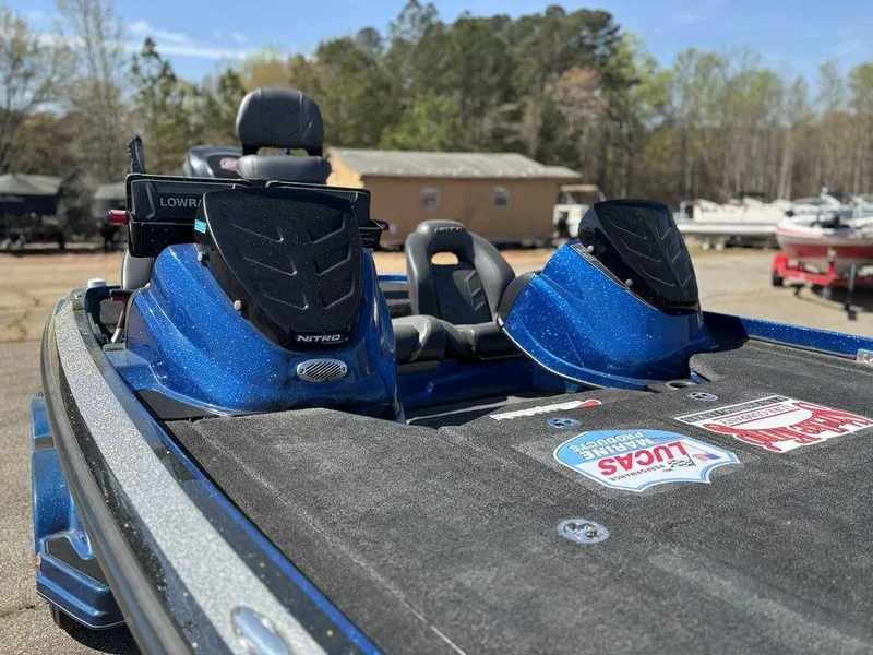 Slide: The Image of 2018 Nitro Z21 boat with blue accents, parked outdoors on a sunny day. - 7