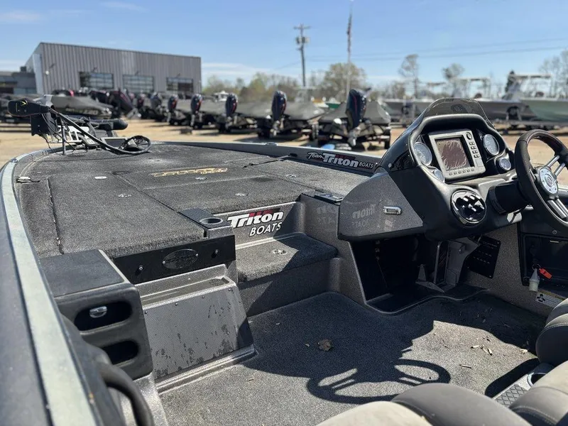 Slide: The Image of 2012 Triton 21 HP boat interior with dashboard and controls, parked outdoors. - 11