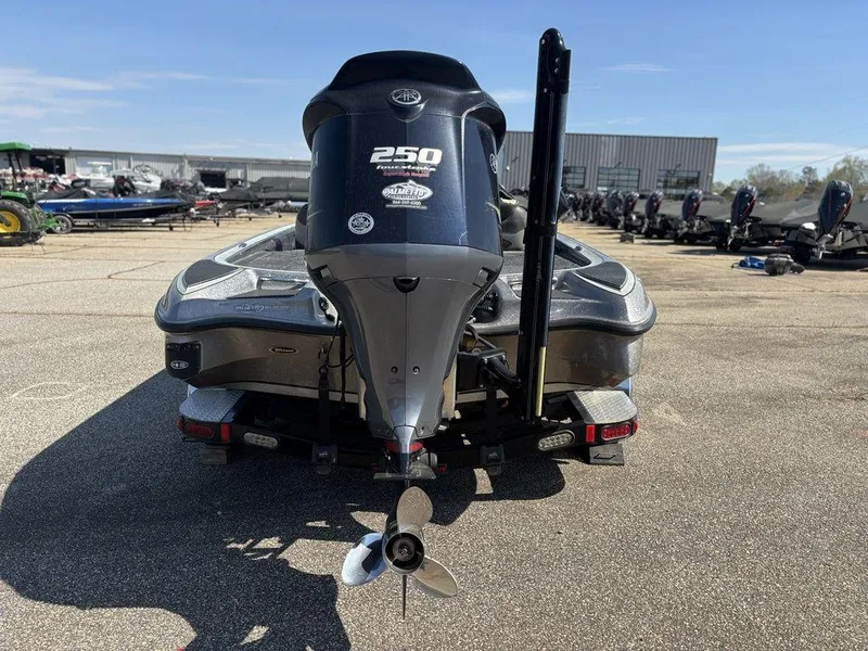 Slide: The Image of 2012 Triton 21 HP boat with powerful 250 HP engine, rear view in parking lot. - 3