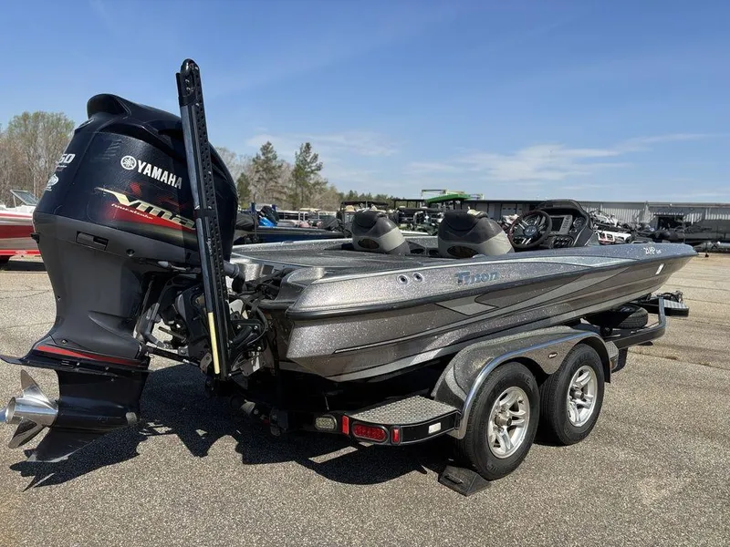 Slide: The Image of 2012 Triton 21 HP boat with Yamaha engine on a trailer, parked outdoors. - 5