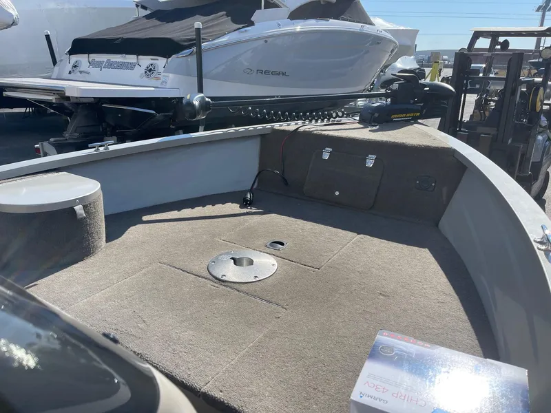 Slide: The Image of 2002 Tracker Super Guide V 16 C boat interior with carpeted deck and storage compartments. - 4