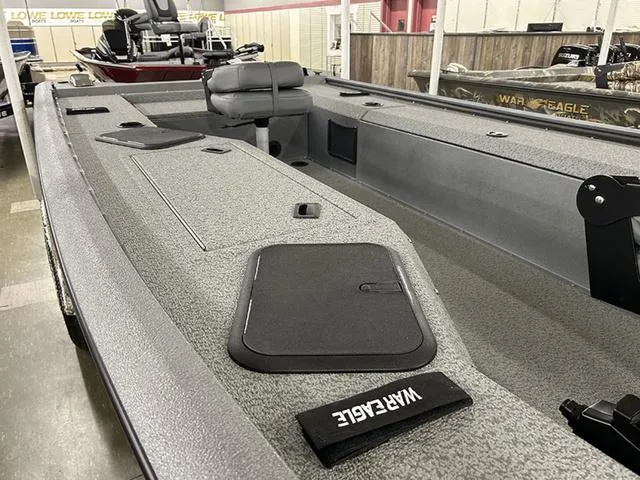 Slide: The Image of 2025 War Eagle 754VS boat interior with seating and storage compartments in showroom. - 4