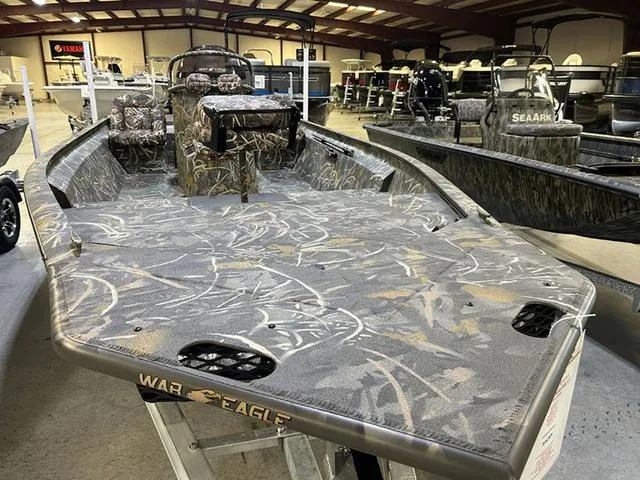 Slide: The Image of 2025 War Eagle 2170 Blackhawk CC boat with camouflage design in a showroom. - 2