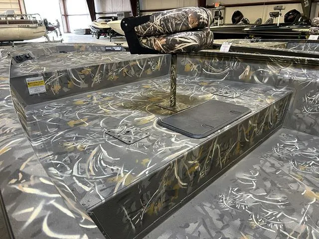 Slide: The Image of 2025 War Eagle 2170 Blackhawk CC boat interior with camouflage design in a showroom. - 4