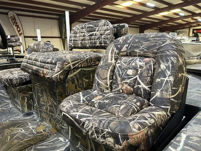 Slide: The Image of 2025 War Eagle 2170 Blackhawk CC boat with camo-patterned seating in a showroom. - 5