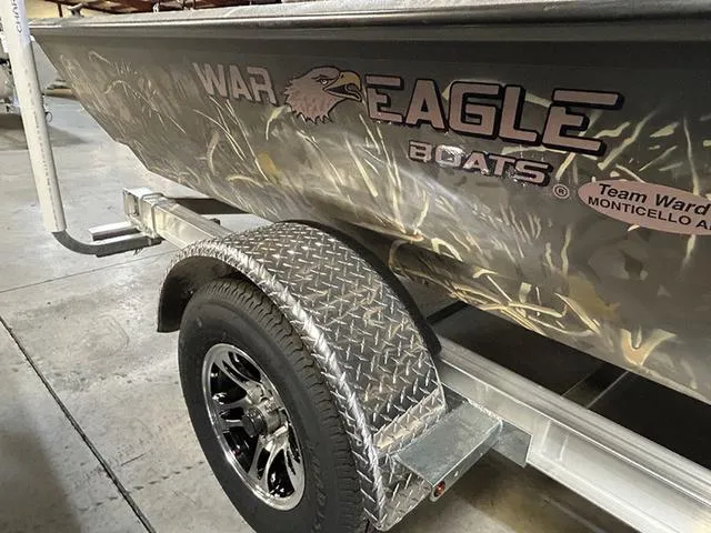 Slide: The Image of 2025 War Eagle 961 Blackhawk CC boat on a trailer, featuring a rugged design and logo. - 10