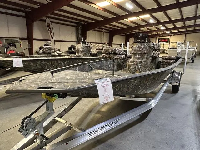 Slide: The Image of 2025 War Eagle 961 Blackhawk CC boat in showroom, camo design, on a trailer. - 3
