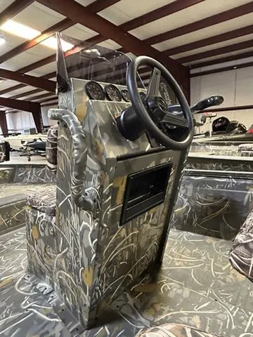 Slide: The Image of 2025 War Eagle 961 Blackhawk CC boat interior with camo design and steering console. - 5