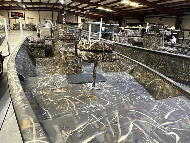 Slide: The Image of 2025 War Eagle 961 Blackhawk CC boat with camouflage interior in a showroom. - 8