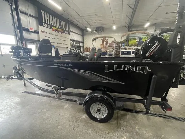 Slide: The Image of 2021 Lund 1650 Rebel XL SS boat in showroom, side view with Mercury engine. - 11
