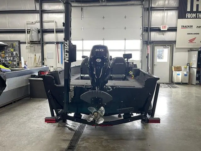 Slide: The Image of 2021 Lund 1650 Rebel XL SS boat in a garage, rear view with motor and propeller. - 8