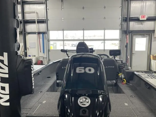 Slide: The Image of 2021 Lund 1650 Rebel XL SS boat in a garage, featuring a 60 HP motor. - 9