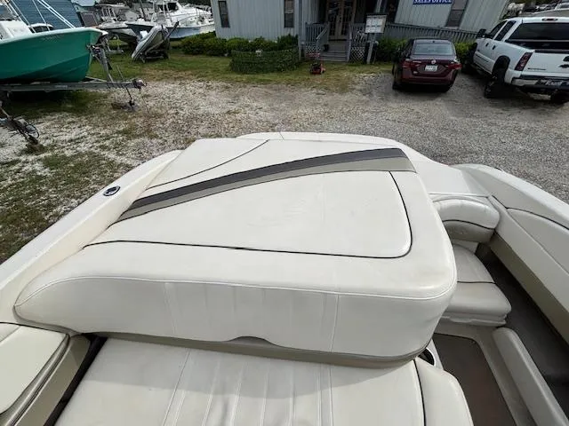 Slide: The Image of 2006 Sea Ray 200 Select boat with white cushioned seating, parked outdoors. - 25
